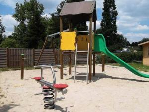 a playground with a slide and a swing set at Mobil-home cosy avec terrasse à Avrillé - API-1-52-490 in Avrillé +6 photos