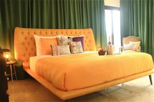 een groot bed met een oranje dekbed in een slaapkamer bij Botanic Home in Marbella