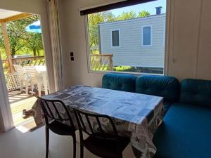 a table and chairs in a living room with a couch at Mobil-home pour 4 pers avec terrasse - API-1-52-494 in Langogne