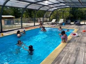 a group of people in a swimming pool at Mobil-home cosy avec terrasse pour 2 personnes - API-1-52-575 in Le Fouilloux