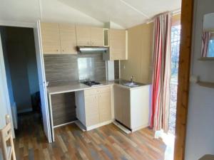 a kitchen with a counter and a sink in it at Mobil-home cosy avec terrasse pour 2 personnes - API-1-52-575 in Le Fouilloux +14 photos