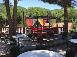 een terras met tafels en stoelen en bomen en bergen bij Mobil-home avec Terrasse - 2 Chambres - API-1-52-552 in Saint-Maime