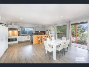 a kitchen and dining room with a white table and chairs at Apartment in Axedale
