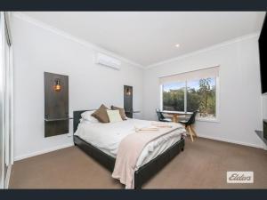 a bedroom with a bed and a table and a window at Apartment in Axedale