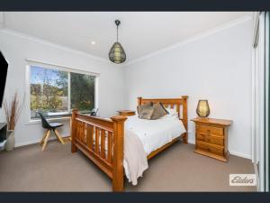 a bedroom with a bed and a desk and a window at Apartment in Axedale