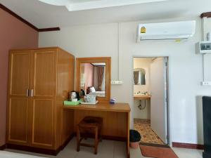 a room with a wooden desk and a mirror at บุรีสอร์ต บุรีรัมย์ Burisort Burirum in Buriram