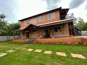 a house with a lawn in front of it at Vara Farm in Kanakapura
