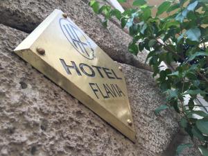 a hotel hilton sign on a stone wall at Hotel Flavia in Rome