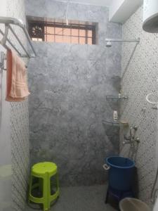 a shower with a green stool in a bathroom at Sirigandha Farms, Near Jog Falls in Talguppa