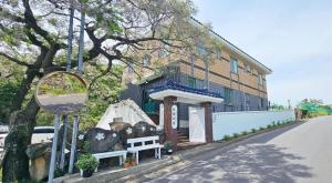 a bench in front of a building on a street at 너랑나랑 게스트하우스 in Seogwipo