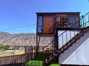 a stairway to a house with mountains in the background at Opensky-kolsai in Saty