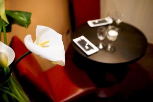a white table topped with a white vase filled with flowers at Hotel Incontro in Ariano Irpino