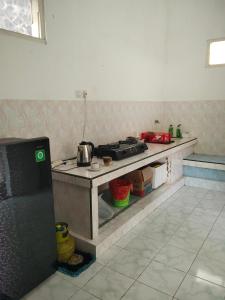 a kitchen with a stove and a counter top at Cozy Corner House in Banyuwangi