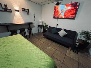 a room with a bed and a couch and a bar at Hidden House in Antigua Guatemala
