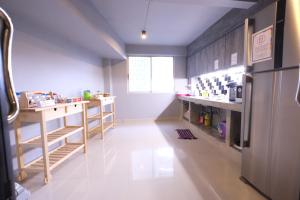 a kitchen with a refrigerator and a white floor at Everyday Bangkok Hostel in Bangkok