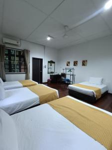 a room with three beds in a room at Mulu National Park in Mulu