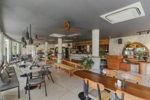 a restaurant with tables and chairs and a bar at Soulshine Resort Ubud, Bali in Ubud