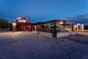 a parking lot in front of a store at night at Frantz Inn in Steinbach