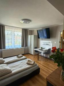 a hotel room with a bed and a table and a dining room at Garden Apartments in Kráľovský Chlmec