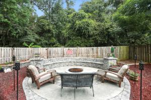 a fire pit in a backyard with chairs and a table at Lowcountry Luxury Near Palmetto Bluff home in Hardeeville
