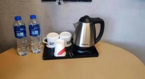 a coffee maker and two bottles of water on a table at Thank Inn Hotel Anqing Guangcai Big Market Passenger Center in Anqing