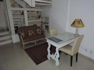 a room with a table and a chair and a lamp at Pousada Don Alberto's in Florianópolis