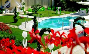 Hotel Incontro في أريانو إربينو: مسبح في ساحة فيها ورد احمر