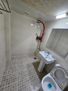 a bathroom with a toilet and a sink at Hue Stay in Busan