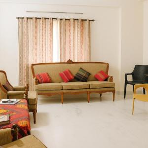 a living room with a couch with red pillows at Cosy Heights Vizag in Visakhapatnam