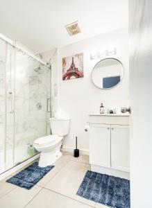 a white bathroom with a shower and a toilet at Séjour agréable à Griffintown 2 chambres in Montréal