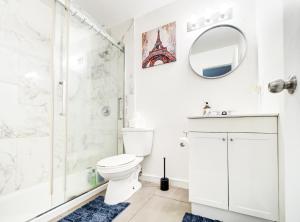a white bathroom with a shower and a toilet at Séjour agréable à Griffintown 2 chambres in Montréal +22 photos