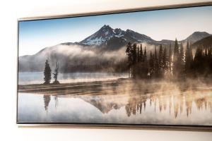 a picture frame hanging on a wall with a lake and mountains at Séjour agréable à Griffintown 2 chambres in Montréal