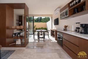 a kitchen with a table and a dining room at Peregrina Tulum 109 1BR Luxury Condo in Tulum