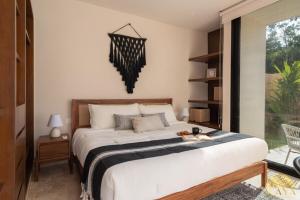 a bedroom with a large bed and a window at Peregrina Tulum 109 1BR Luxury Condo in Tulum +42 photos