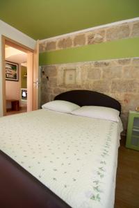 um quarto com uma cama grande e uma parede de tijolos em Dalmatian Stone House em Krapanj