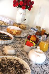 una mesa cubierta con comida y frutas y un jarrón de flores en Da Foschetta, en Matelica