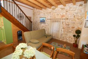 uma sala de estar com um sofá e uma parede de pedra em Dalmatian Stone House em Krapanj