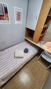 a bed in a room with a desk and a bed sidx sidx sidx at Time Stay in Busan