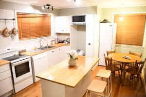 Una cocina con una mesa con un jarrón de flores encima. en Homely Cosy small house, en Lower Hutt