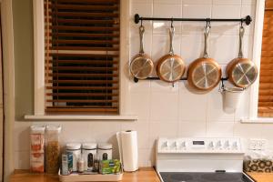 Una cocina con ollas y sartenes de cobre colgadas en la pared. en Homely Cosy small house, en Lower Hutt 5 fotos más