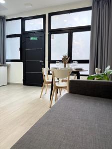 une salle à manger avec une table, des chaises et des fenêtres dans l'établissement APARTAMENTOS CIUDAD DE LAS ARTES Y LAS CIENCIAS, à Valence