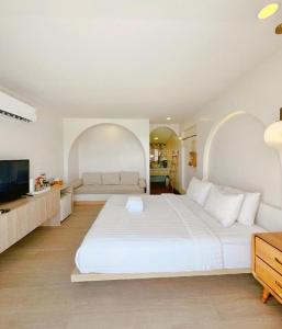 a bedroom with a large white bed and a television at Sawasdee Coco Resort in Ko Samed