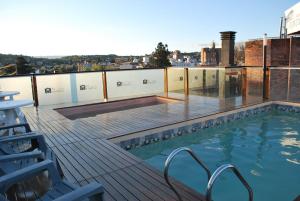a swimming pool on the roof of a building at Apart Hotel El Portico in Villa Carlos Paz