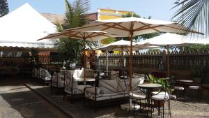 a restaurant with tables and chairs under umbrellas at The Colonial Guest House in São Filipe
