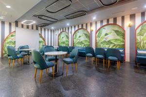 a waiting room with blue chairs and tables and a whiteboard at Treebo Terrazzo Suites in Ahmedabad