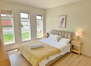 Un dormitorio con una cama y dos ventanas. en Spacious 4-Bedroom Family Home | Quiet & Connected, en Truganina