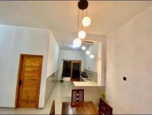 a dining room with a wooden table and a kitchen at Gareka villa in Amed