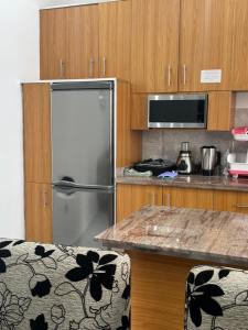 a kitchen with a stainless steel refrigerator and wooden cabinets at Résidence Fagnon in Cotonou