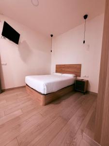 une chambre avec un lit blanc et un parquet dans l'établissement APARTAMENTOS CIUDAD DE LAS ARTES Y LAS CIENCIAS, à Valence