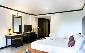 a bedroom with a bed and a desk and a mirror at Town In Town Gardent Resort in Sathani Khlong Tan
